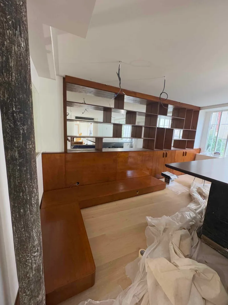 Bibliothèque sur mesure en bois verni avec niches, miroirs et rangements bas