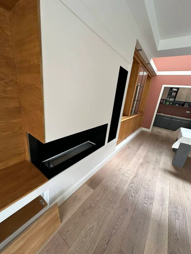 Vue latérale de la cheminée horizontale noire et des encadrements en bois