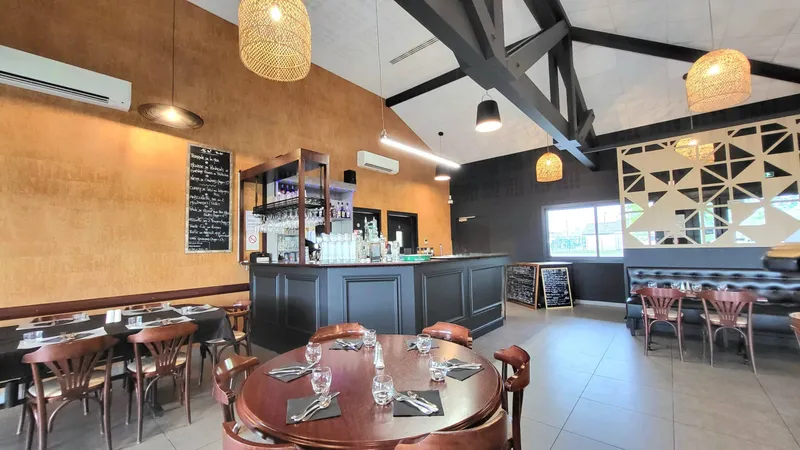 Intérieur de restaurant contemporain avec bar, tables dressées et luminaires suspendus