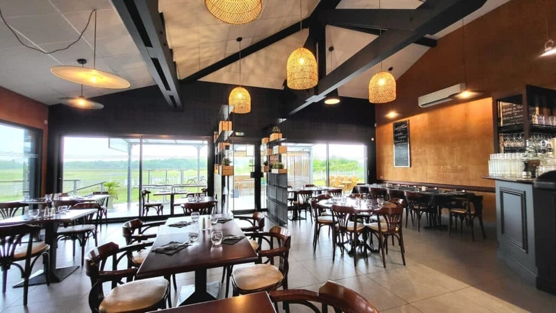 Restaurant contemporain avec tables en bois, suspensions tressées et larges baies vitrées