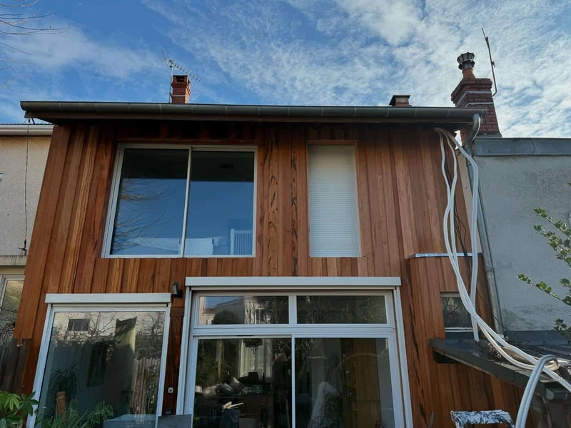Façade de maison en bardage bois avec plusieurs baies vitrées